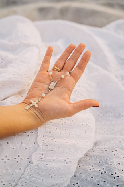 Close-up of a person's hands in a prayer pose, with a serene and warm background light.