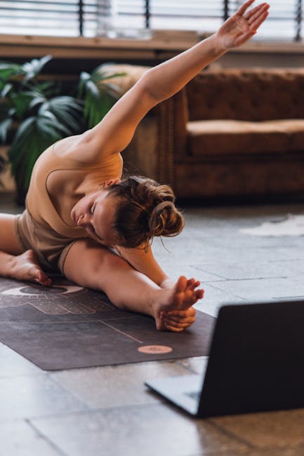 Woman in a comfortable seated yoga pose on a terracotta mat greeting the morning sun from her balcony.